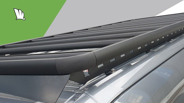 Front corner of the Mercedes-Benz Sprinter with Wedgetail roof rack installed showing the fixing points for the one piece mounting rail, the platform attached to the mounting rail and the wind deflector mounted to the front of the rack.