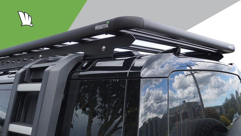 Rear passenger side corner of the Defender 110 showing the allowances made in the one piece mounting rails for accessories such as the step ladder. The mounting rails also provide the height to clear the Wedgetail roof rack of aerials and the sun roof.