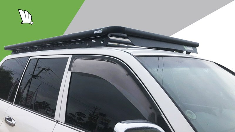 Front driver side view of a Toyota LandCruiser 100 Series with a Wedgetail roof rack installed and showing the one piece Wedge-wing mounting rails, the platform roof rack and the attached wind deflector.